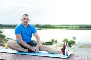Man stretching leg on ground - stretching exercises for men