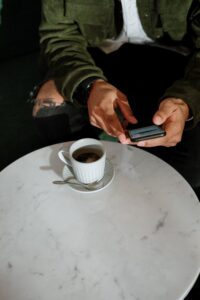 Guy drinking coffee texting