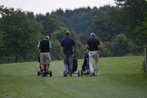 3 guys playing golf - building and maintaining social connections for men