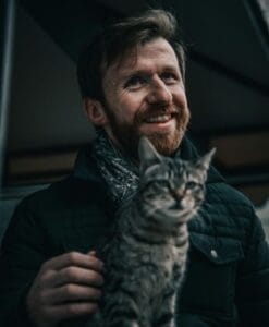 man petting cat on his lap embracing mindfulness