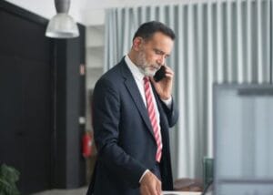 office man standing while on phone - Keep moving