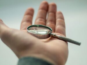 magnifying glass on man's hand - micro habits