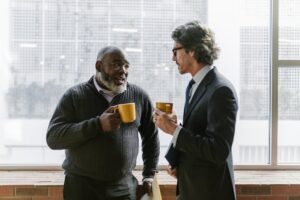 two middle age men drinking coffee - pros and cons of coffee