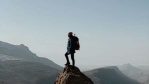 hiker on summit of mountain - challenge yourself to build confidence after 50