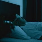 man sleeping with sleep mask on -avoid electronics before bed