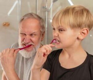 Grandfather and grandson brushing their teeth - Brush Your Teeth Regularly