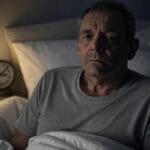Man awake in bed during the night