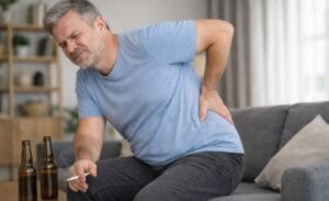 Middle age man getting up from sofa with pain